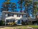 Inviting two-story home with white siding, black shutters, a well-maintained lawn, and an attached carport at 304 Northbrook Dr, Raleigh, NC 27609