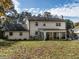 Back exterior view featuring a sunroom, well-maintained lawn, and classic architectural details at 304 Northbrook Dr, Raleigh, NC 27609