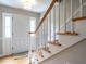Inviting foyer featuring hardwood floors, staircase with white spindles and wood rail, and bright, natural lighting at 304 Northbrook Dr, Raleigh, NC 27609