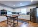 Well-lit kitchen with white cabinets, stainless steel appliances, and a large island with wine storage at 304 Northbrook Dr, Raleigh, NC 27609