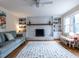 Bright living room featuring a painted brick fireplace with a wooden mantel, built-in shelves and a plush sofa at 304 Northbrook Dr, Raleigh, NC 27609