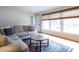 Sunlit living room with windows, hardwood floors, and comfortable seating with area rug at 304 Northbrook Dr, Raleigh, NC 27609