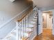 Carpeted staircase with white wood risers and balusters, and wood railing leads to the upper level at 304 Northbrook Dr, Raleigh, NC 27609