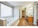 Spacious bathroom with a large window, tub, and separate vanity area at 309 Malvern Hill Ln, Morrisville, NC 27560