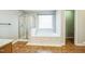 Bright bathroom featuring a walk-in shower and a soaking tub at 309 Malvern Hill Ln, Morrisville, NC 27560