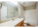 Bathroom with oak vanity, stone countertop, white sink, and shower at 309 Malvern Hill Ln, Morrisville, NC 27560