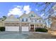 Charming two-story home featuring a stone facade, three-car garage, and inviting front porch at 309 Malvern Hill Ln, Morrisville, NC 27560
