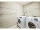 Bright laundry room with washer, dryer, and shelving at 309 Malvern Hill Ln, Morrisville, NC 27560