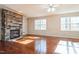 Bright living room with hardwood floors, a stone fireplace, and a ceiling fan at 309 Malvern Hill Ln, Morrisville, NC 27560
