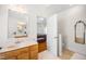Bright bathroom with a sink, a doorway leading to a bedroom, and decorative mirrors at 3337 Scarlet Oak Dr, Mebane, NC 27302