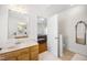 Bright bathroom with a sink, a doorway leading to a bedroom, and decorative mirrors at 3337 Scarlet Oak Dr, Mebane, NC 27302