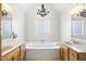Bathroom featuring double sinks, a soaking tub, a chandelier, and a privacy window at 3337 Scarlet Oak Dr, Mebane, NC 27302