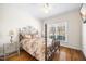 Cozy bedroom with hardwood floors, a wrought iron bed frame, and a bright window view at 3337 Scarlet Oak Dr, Mebane, NC 27302