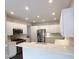 A modern kitchen boasts white cabinets, stainless steel appliances, and a quartz countertop island at 3337 Scarlet Oak Dr, Mebane, NC 27302