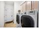 Modern laundry room with washer, dryer, storage cabinets, and tile flooring at 3337 Scarlet Oak Dr, Mebane, NC 27302