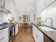 Modern kitchen flowing into dining area, featuring stainless steel appliances and white cabinets at 3343 Ridgecrest Ct, Raleigh, NC 27607