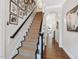 Elegant staircase with carpet runner, dark wood banister, and gallery wall of art and photos at 3343 Ridgecrest Ct, Raleigh, NC 27607