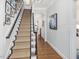 Elegant staircase with carpet runner, dark wood banister, and gallery wall of art and photos at 3343 Ridgecrest Ct, Raleigh, NC 27607