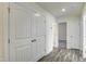 Hallway with wood-look floors and white doors, creating a bright and airy atmosphere at 3505 Triad Ct, Raleigh, NC 27604