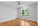 Bright bedroom featuring hardwood floors, neutral walls, ceiling fan, and a large window overlooking the lawn at 3909 Cedar Knolls Dr # 6, Youngsville, NC 27596