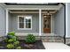 Inviting front porch with wood door, stone accents, detailed trim, and tasteful landscaping at 3909 Cedar Knolls Dr # 6, Youngsville, NC 27596