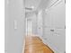Hallway featuring hardwood floors and neutral walls leading to several bright white doors at 3909 Cedar Knolls Dr # 6, Youngsville, NC 27596