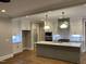 Bright kitchen features a large island, white cabinets, stainless steel appliances and modern pendant lighting at 3909 Cedar Knolls Dr # 6, Youngsville, NC 27596