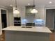 Stylish island kitchen with a gray island, white cabinets, and stainless appliances at 3909 Cedar Knolls Dr # 6, Youngsville, NC 27596