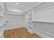 The spacious walk-in closet features wood floors and built-in shelving and hanging rods at 3909 Cedar Knolls Dr # 6, Youngsville, NC 27596