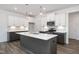 Modern kitchen boasts stainless steel appliances, gray island, stylish lighting, and ample counter space at 3920 Willow Gate Way, Raleigh, NC 27604