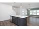 Kitchen island featuring a stainless-steel sink, seating, dishwasher and stylish pendant lighting at 3920 Willow Gate Way, Raleigh, NC 27604
