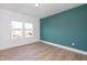 Bedroom with wood-look floors, teal accent wall, and a large window for natural light at 3928 Willow Gate Way, Raleigh, NC 27604