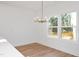 Bright dining room with wood floors, a modern chandelier, and a large window at 3928 Willow Gate Way, Raleigh, NC 27604