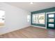 Entryway with wood-look floors, teal accent wall, multiple windows, and a modern front door at 3928 Willow Gate Way, Raleigh, NC 27604