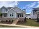 Inviting gray two-story home showcasing a lovely front porch with brick base and newly landscaped front yard at 3928 Willow Gate Way, Raleigh, NC 27604