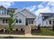 Charming gray two-story home featuring a welcoming front porch with brick base and landscaped front yard at 3928 Willow Gate Way, Raleigh, NC 27604