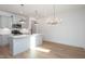 Modern kitchen with white cabinets, quartz countertops, stainless steel appliances, and wood-look flooring at 3928 Willow Gate Way, Raleigh, NC 27604