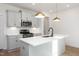 Bright kitchen with an island, white cabinets, quartz countertops, stainless steel appliances, and modern lighting at 3928 Willow Gate Way, Raleigh, NC 27604