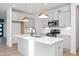 Open kitchen features stainless appliances, gray cabinets, large island and modern pendant lights at 3928 Willow Gate Way, Raleigh, NC 27604