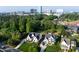 Aerial view showcases two modern homes with well-kept lawns and mature trees, set against a cityscape at 4329 Lambeth Dr, Raleigh, NC 27609