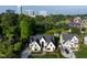 Aerial view of a modern home with well-manicured lawn, mature trees, and a cityscape backdrop at 4329 Lambeth Dr, Raleigh, NC 27609