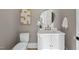 Stylish half-bathroom features white vanity, modern round mirror and lovely decor at 4329 Lambeth Dr, Raleigh, NC 27609