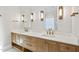 Bright bathroom boasts double sinks, wood cabinetry, and stylish modern lighting at 4329 Lambeth Dr, Raleigh, NC 27609