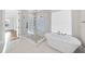 Modern bathroom featuring a glass enclosed shower and soaking tub with elegant fixtures and bright natural light at 4329 Lambeth Dr, Raleigh, NC 27609