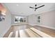 Light-filled bedroom featuring hardwood floors, a ceiling fan and three large windows at 4329 Lambeth Dr, Raleigh, NC 27609