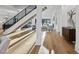 Open concept foyer with hardwood floors, a staircase with black railings, and views into the living room at 4329 Lambeth Dr, Raleigh, NC 27609