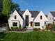 Stunning white brick home with a modern design, dark trim, and professional landscaping in a lush green setting at 4329 Lambeth Dr, Raleigh, NC 27609