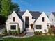 Stunning white brick home with a modern design, dark trim, and professional landscaping in a lush green setting at 4329 Lambeth Dr, Raleigh, NC 27609