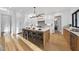 Bright kitchen featuring a large island, modern light fixture, white cabinets, and hardwood floors at 4329 Lambeth Dr, Raleigh, NC 27609