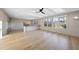 Bright living room with light hardwood floors, ceiling fan, large windows, and built-in TV console at 4329 Lambeth Dr, Raleigh, NC 27609
